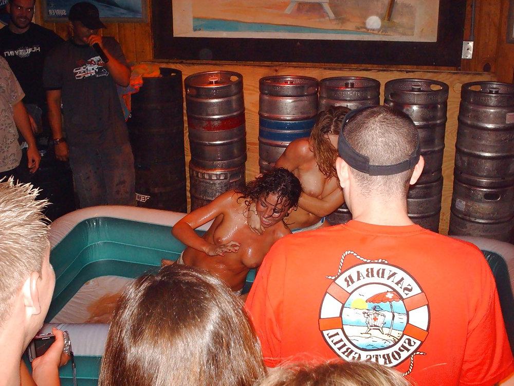 9P Two topless girls play-fighting in a bar