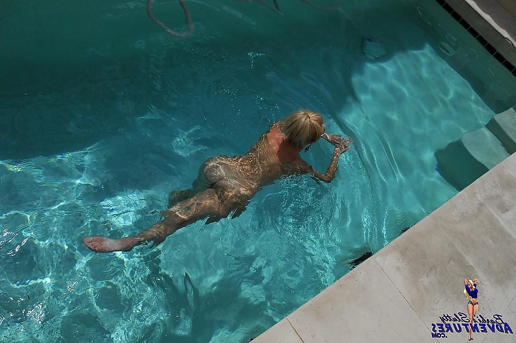 15P Cute blonde MILF Barbi Sinclair shows her fantastic body wearing sexy bikini in the pool.