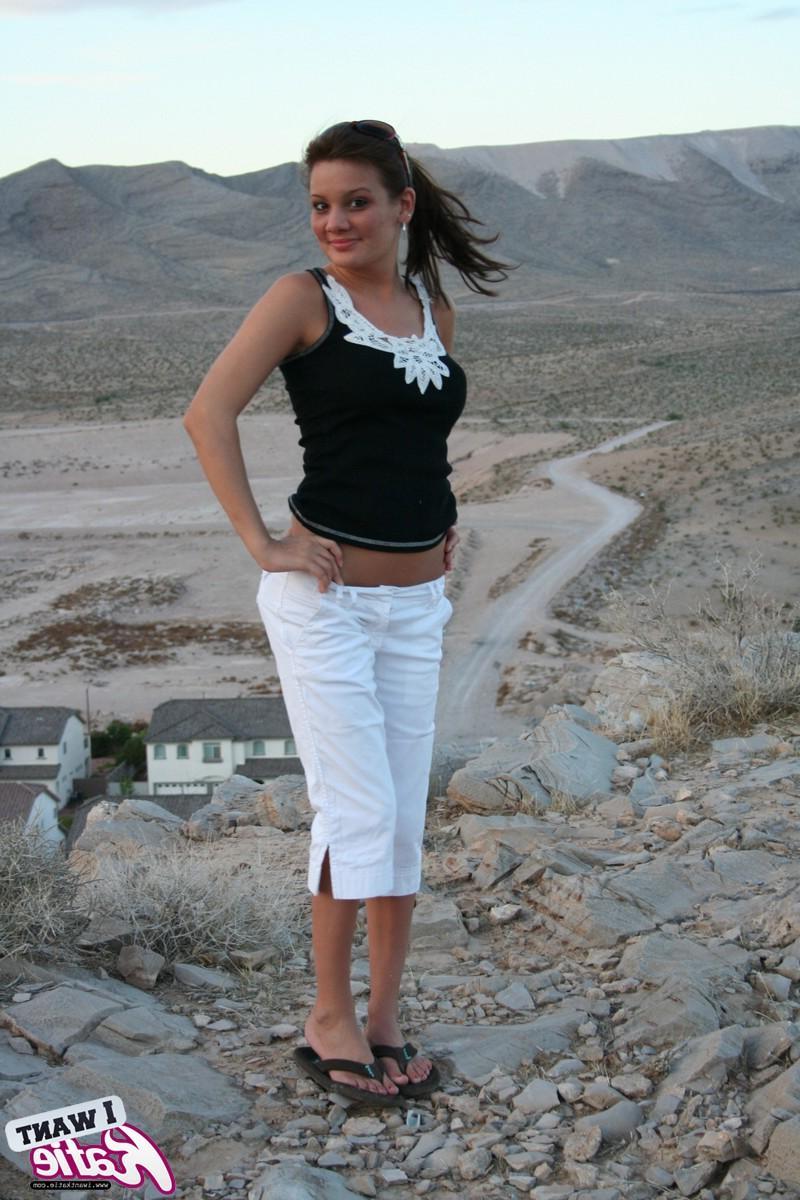 12P Katie strips out of her clothes and exposes her big tits and tight pussy on top of the hill with a view