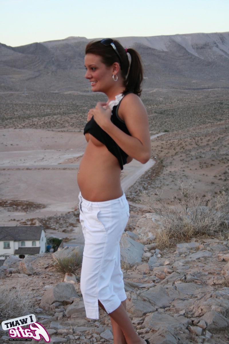 12P Katie strips out of her clothes and exposes her big tits and tight pussy on top of the hill with a view