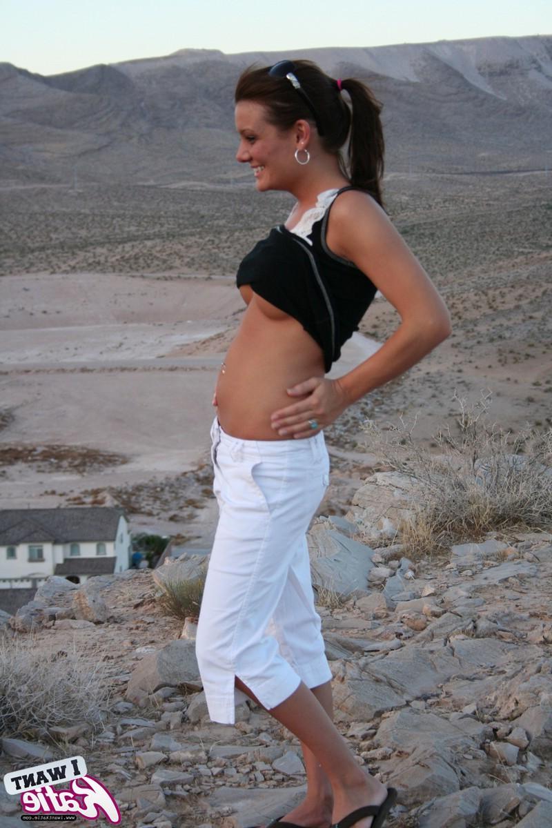 12P Katie strips out of her clothes and exposes her big tits and tight pussy on top of the hill with a view