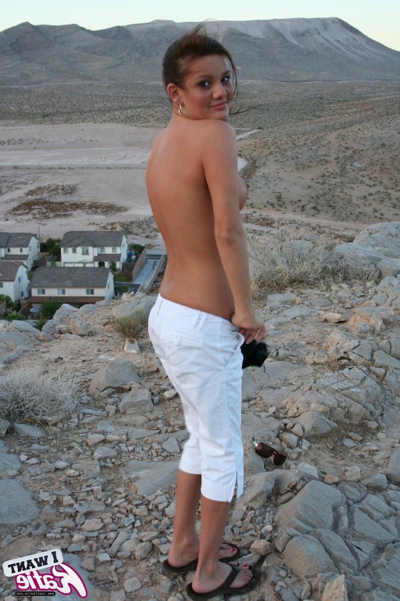 12P Katie strips out of her clothes and exposes her big tits and tight pussy on top of the hill with a view