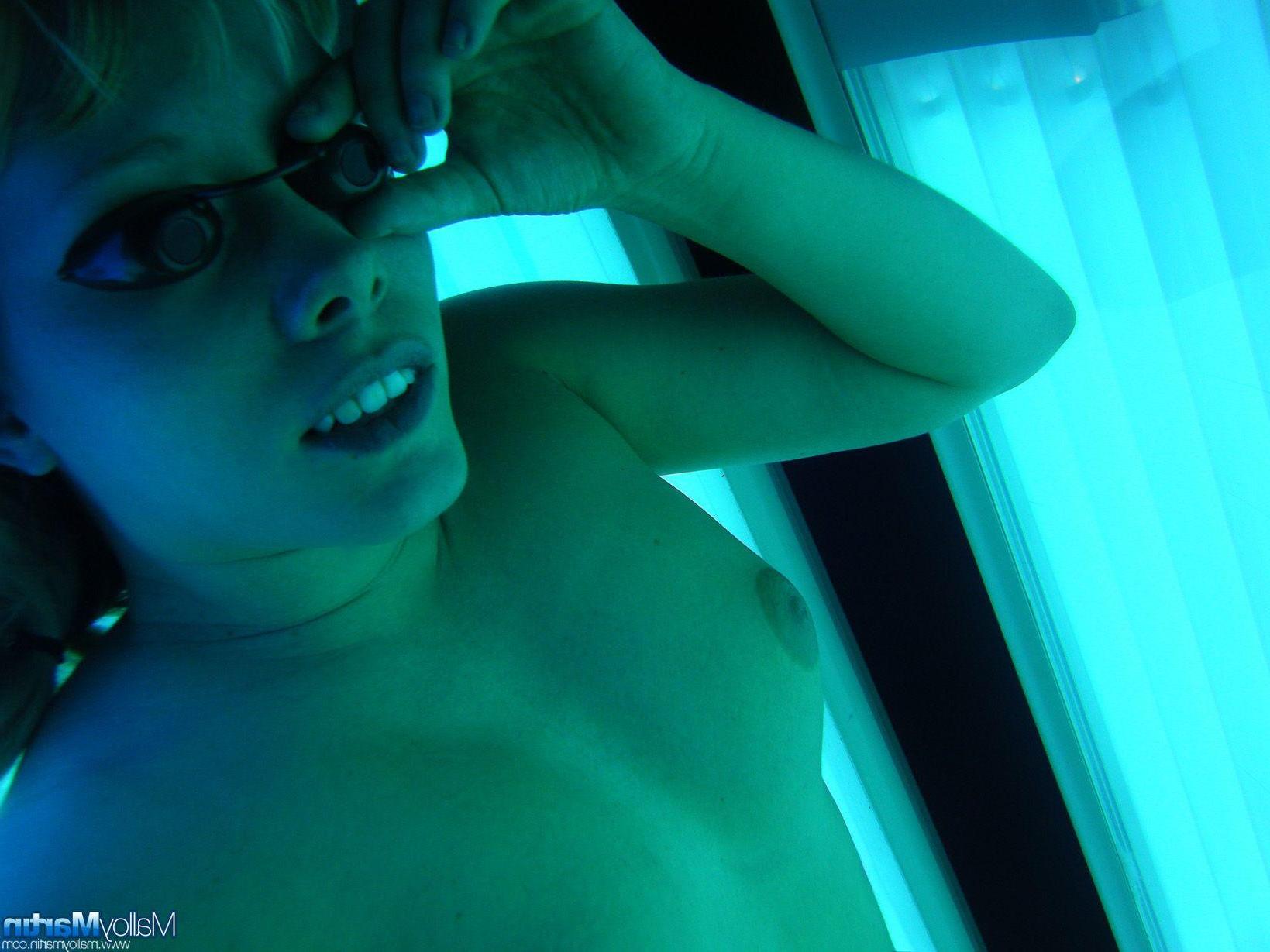 16P Pictures of teen amateur Malloy Martin showing her pussy on a tanning bed