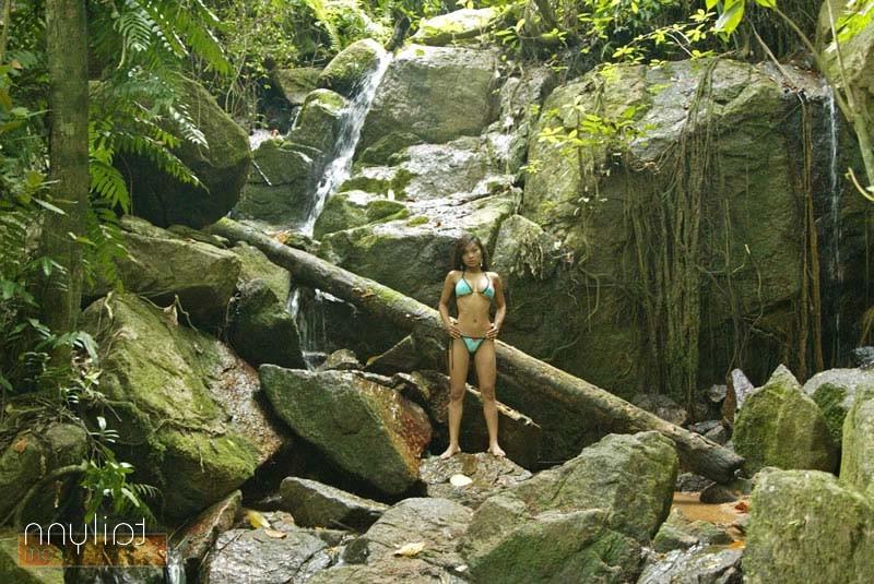 15P Hot Asian Tailynn in a skimpy bikini posing by a waterfall