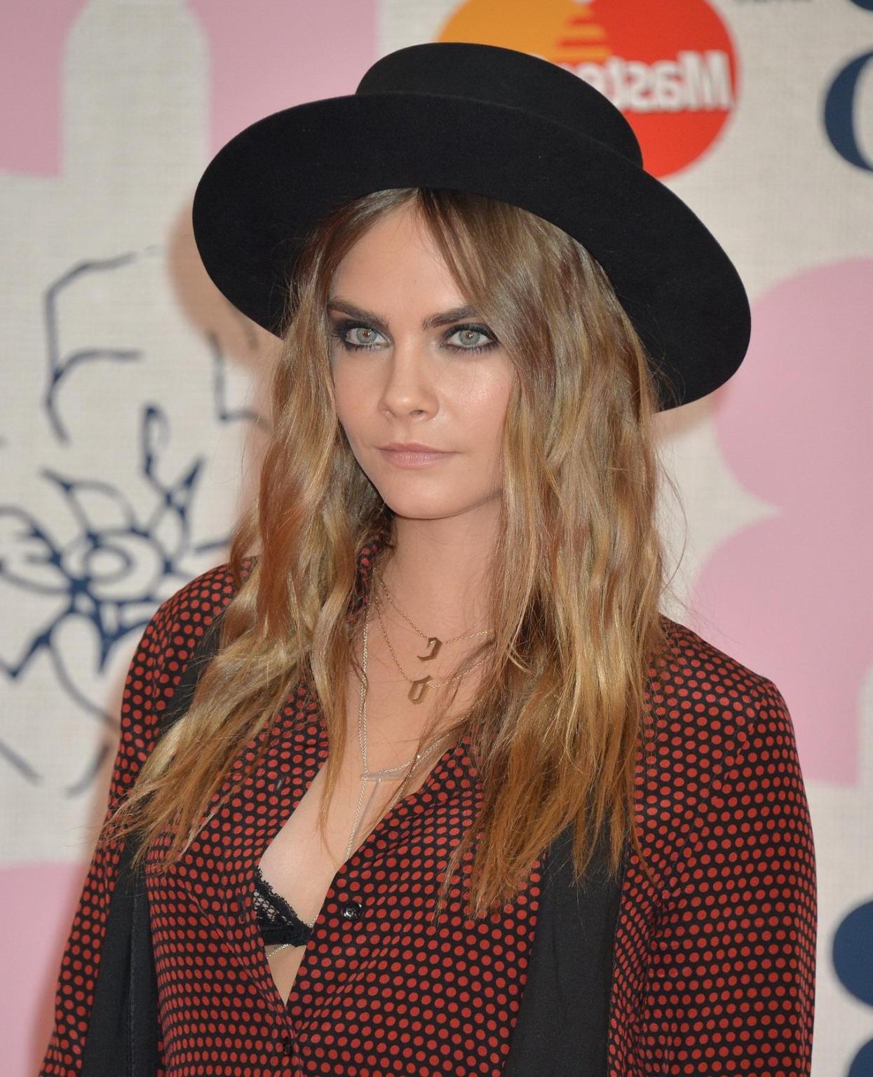 16P Cara Delevingne bra peek at the Brit Awards in London