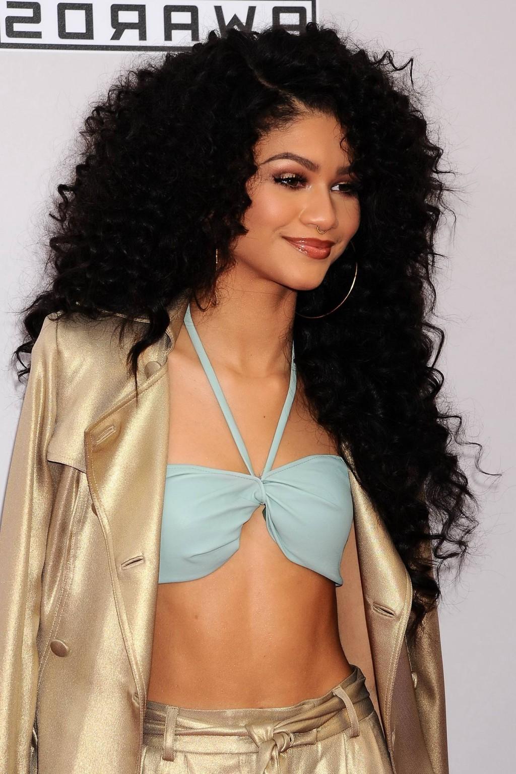 16P Zendaya Coleman wearing hot blue bra under a wide open gold coat at 2014 America