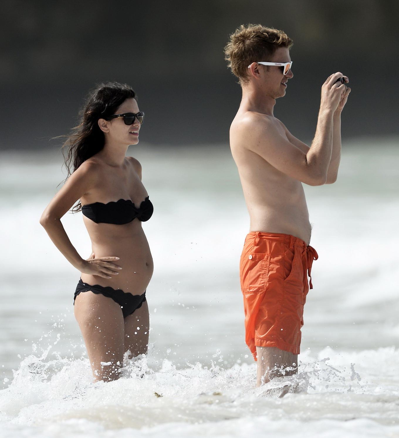 16P Rachel Bilson pregnant wearing a strapless black bikini on a beach in Barbados
