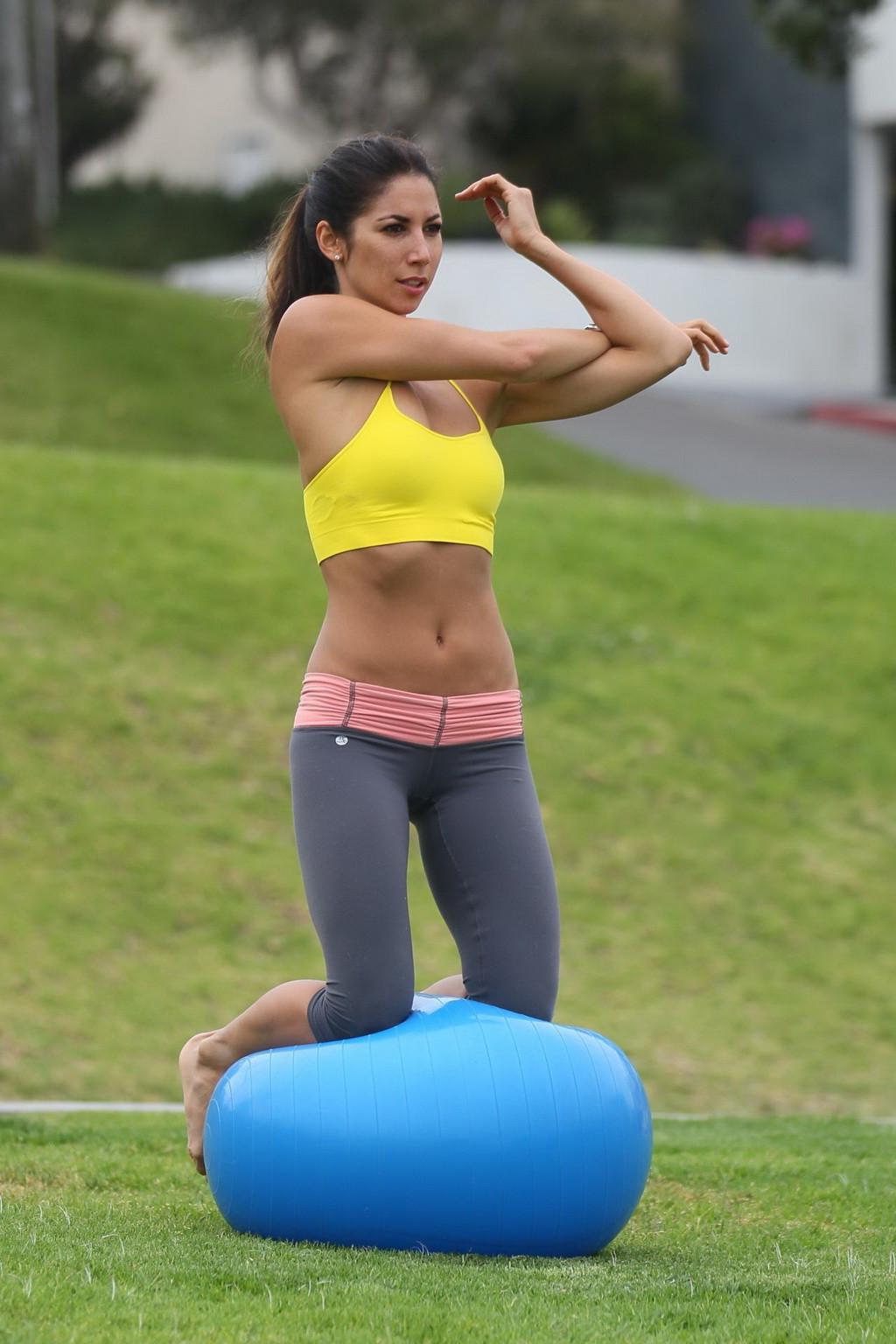 13P Leilani Dowding practicing yoga in a sports bra and leggings at the park in LA