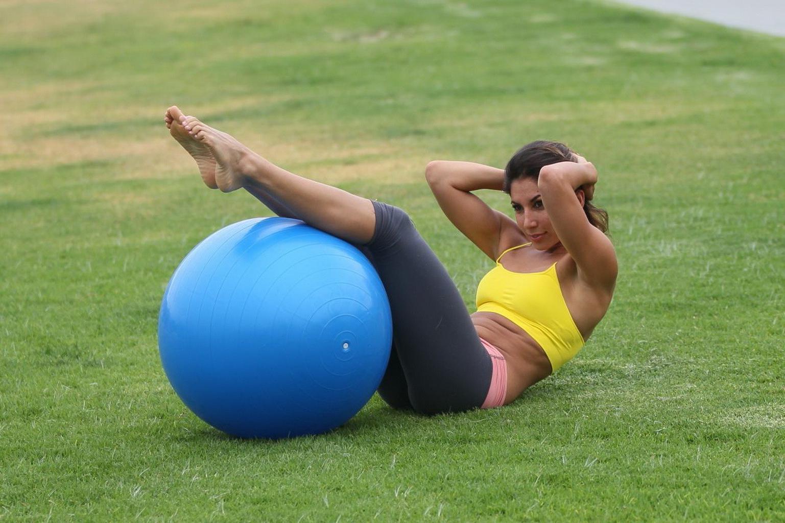 13P Leilani Dowding practicing yoga in a sports bra and leggings at the park in LA