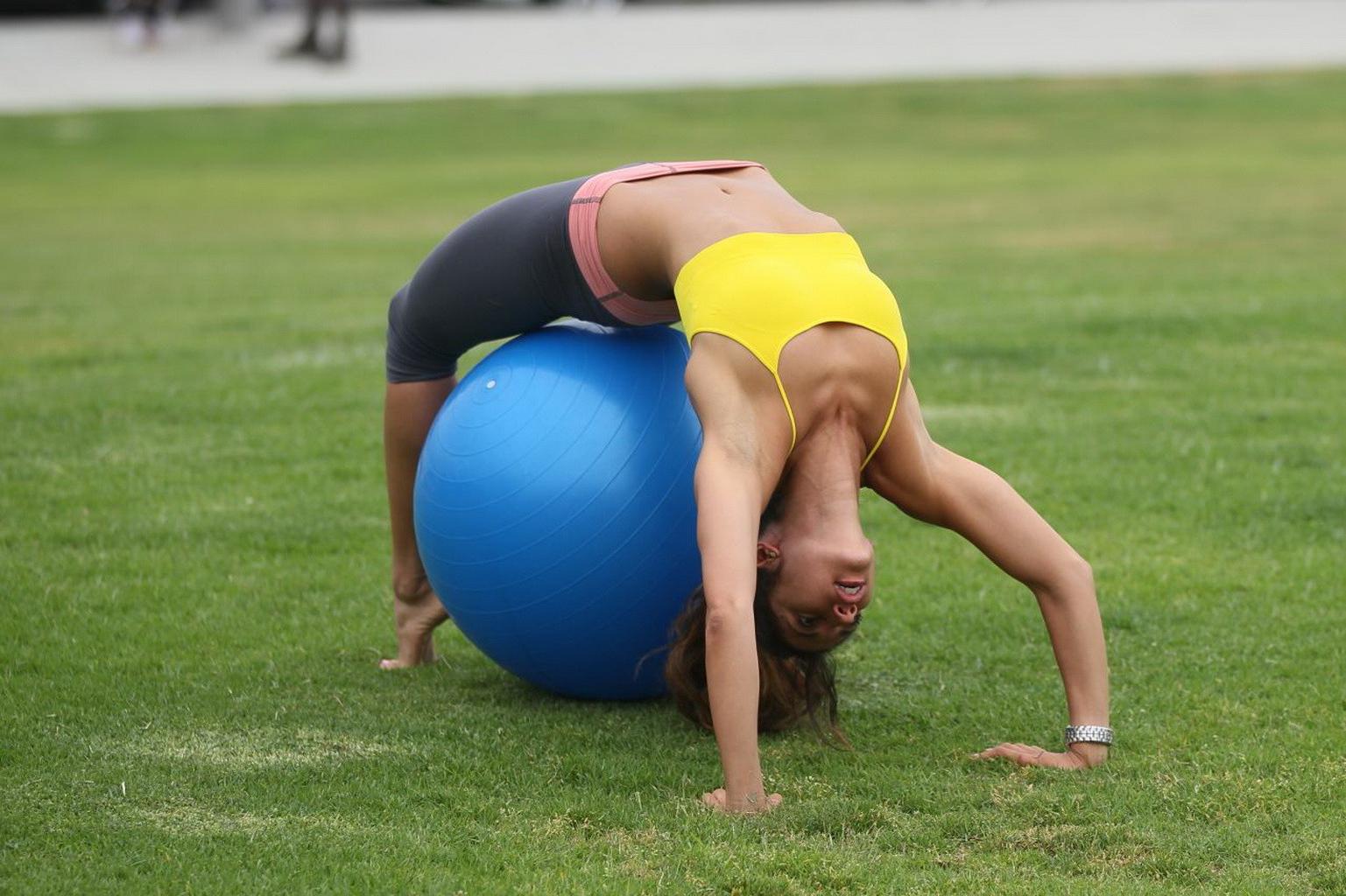 13P Leilani Dowding practicing yoga in a sports bra and leggings at the park in LA