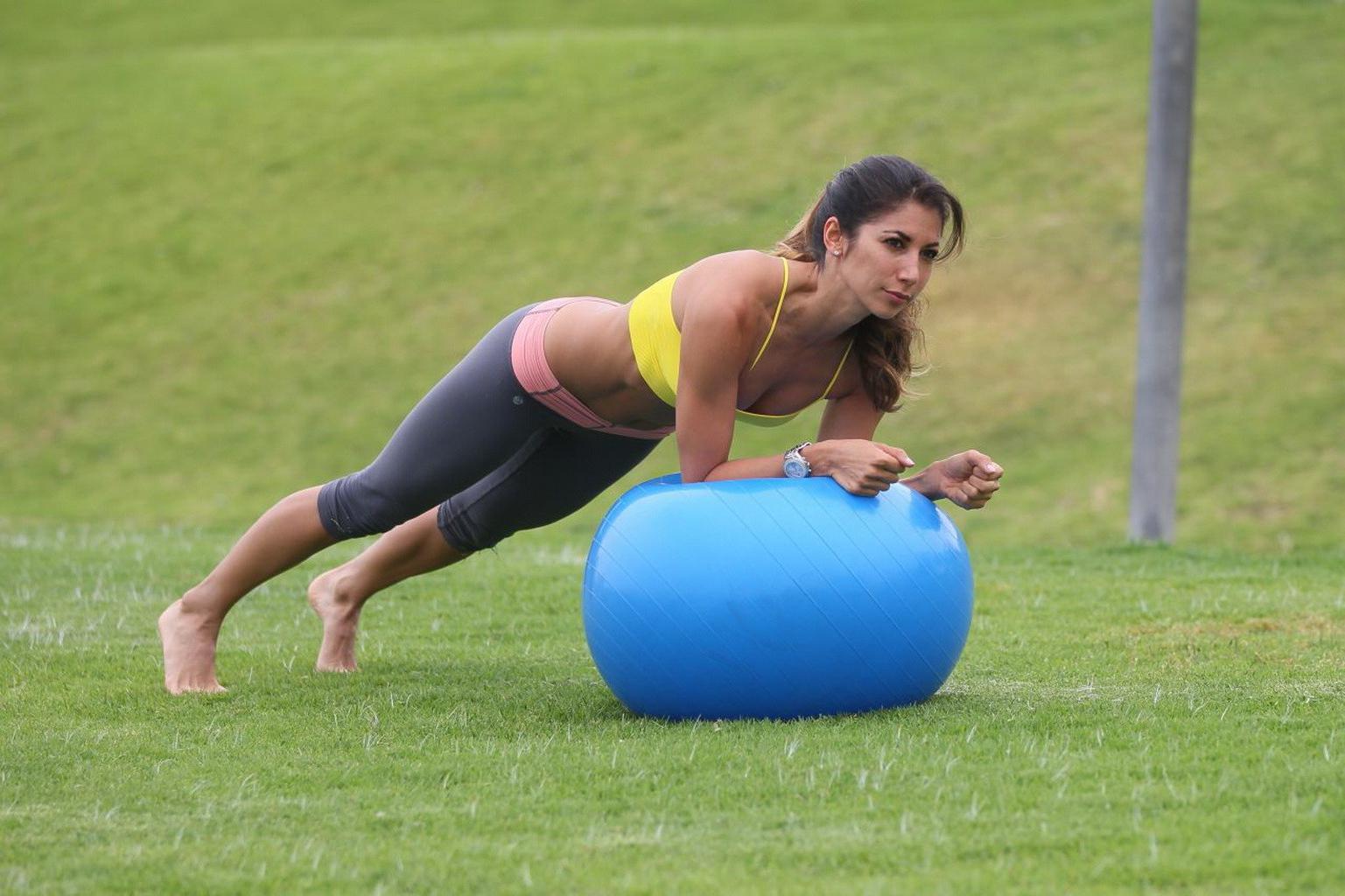 13P Leilani Dowding practicing yoga in a sports bra and leggings at the park in LA