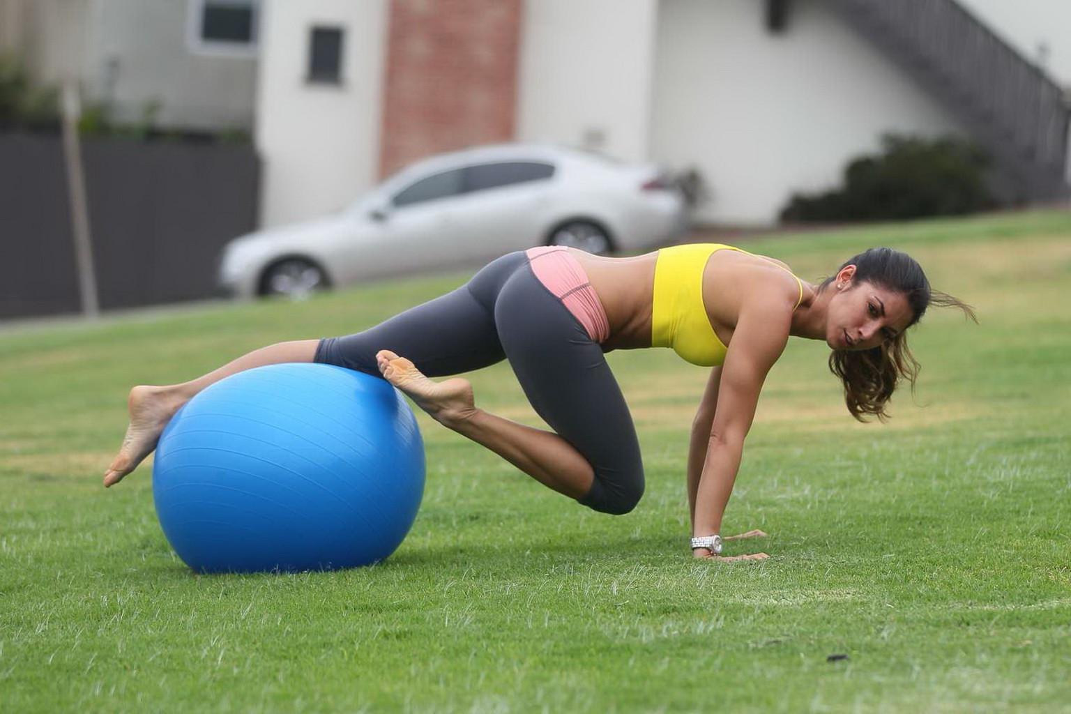 13P Leilani Dowding practicing yoga in a sports bra and leggings at the park in LA