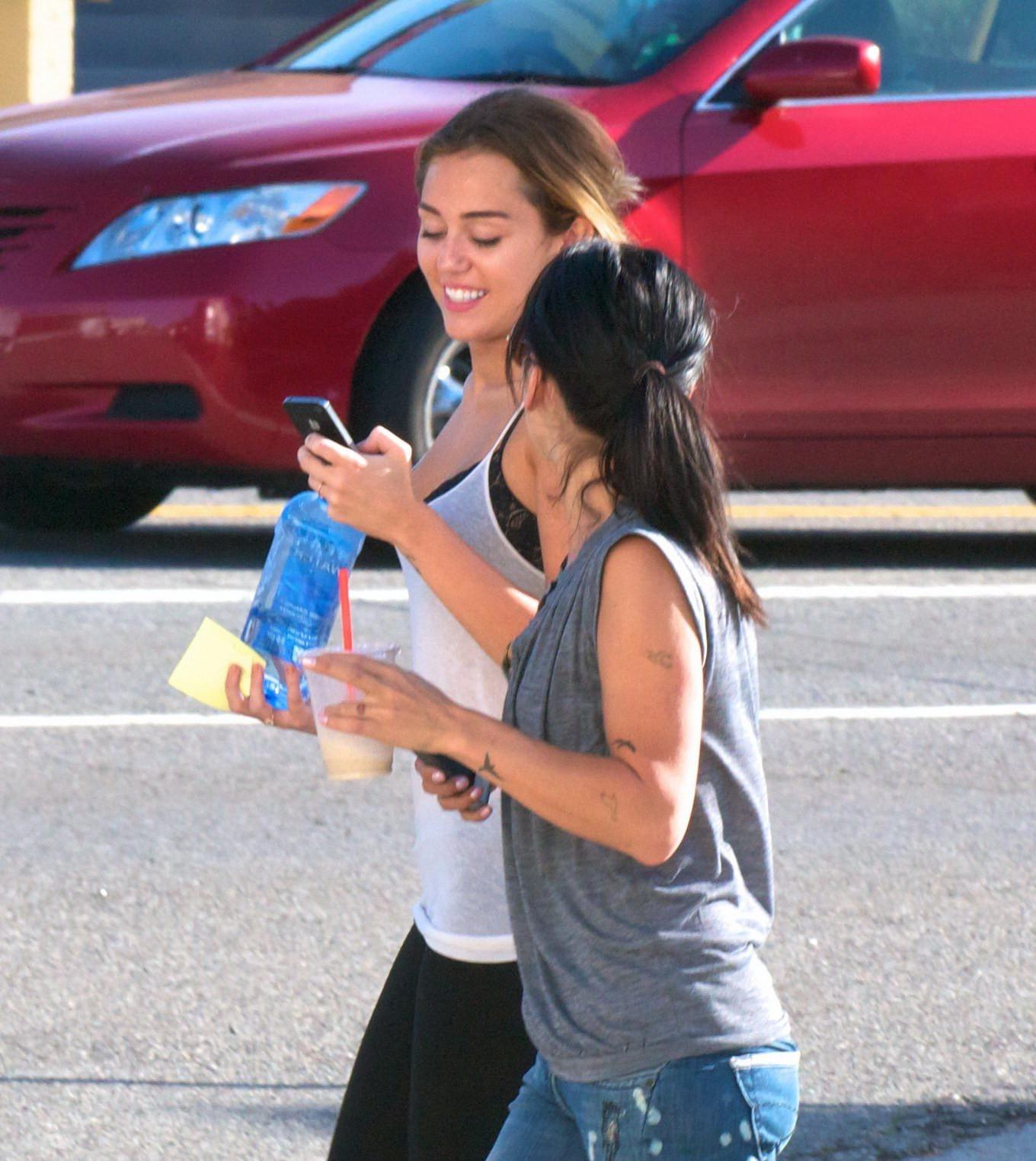 16P Miley Cyrus see-through to bra leaving a pilates class in LA