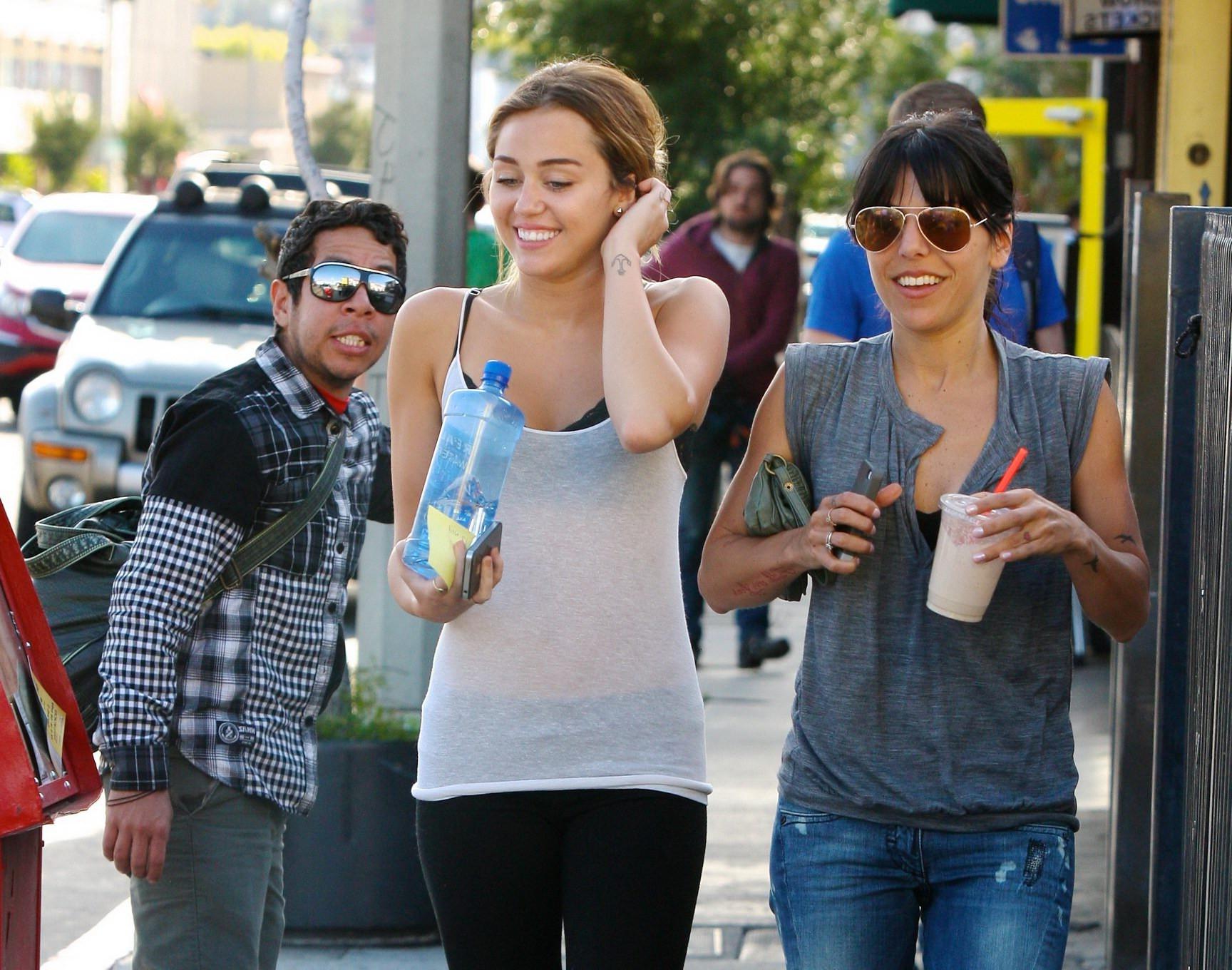 16P Miley Cyrus see-through to bra leaving a pilates class in LA