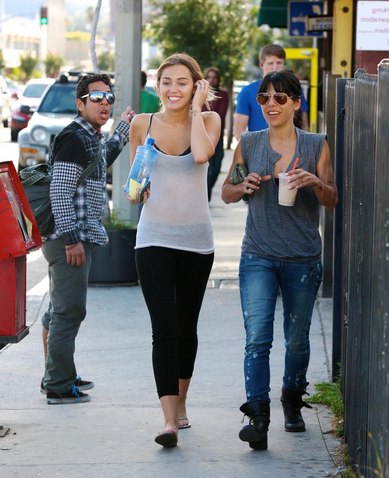 16P Miley Cyrus see-through to bra leaving a pilates class in LA