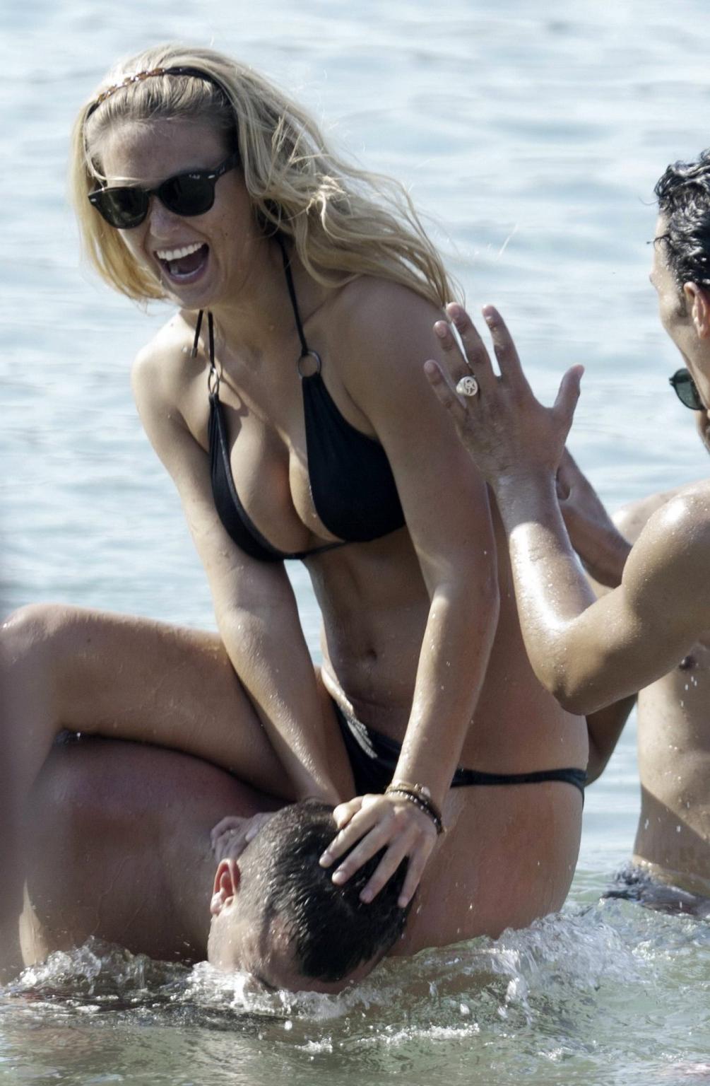 16P Bar Refaeli busty wearing black bikini on a beach in Greece