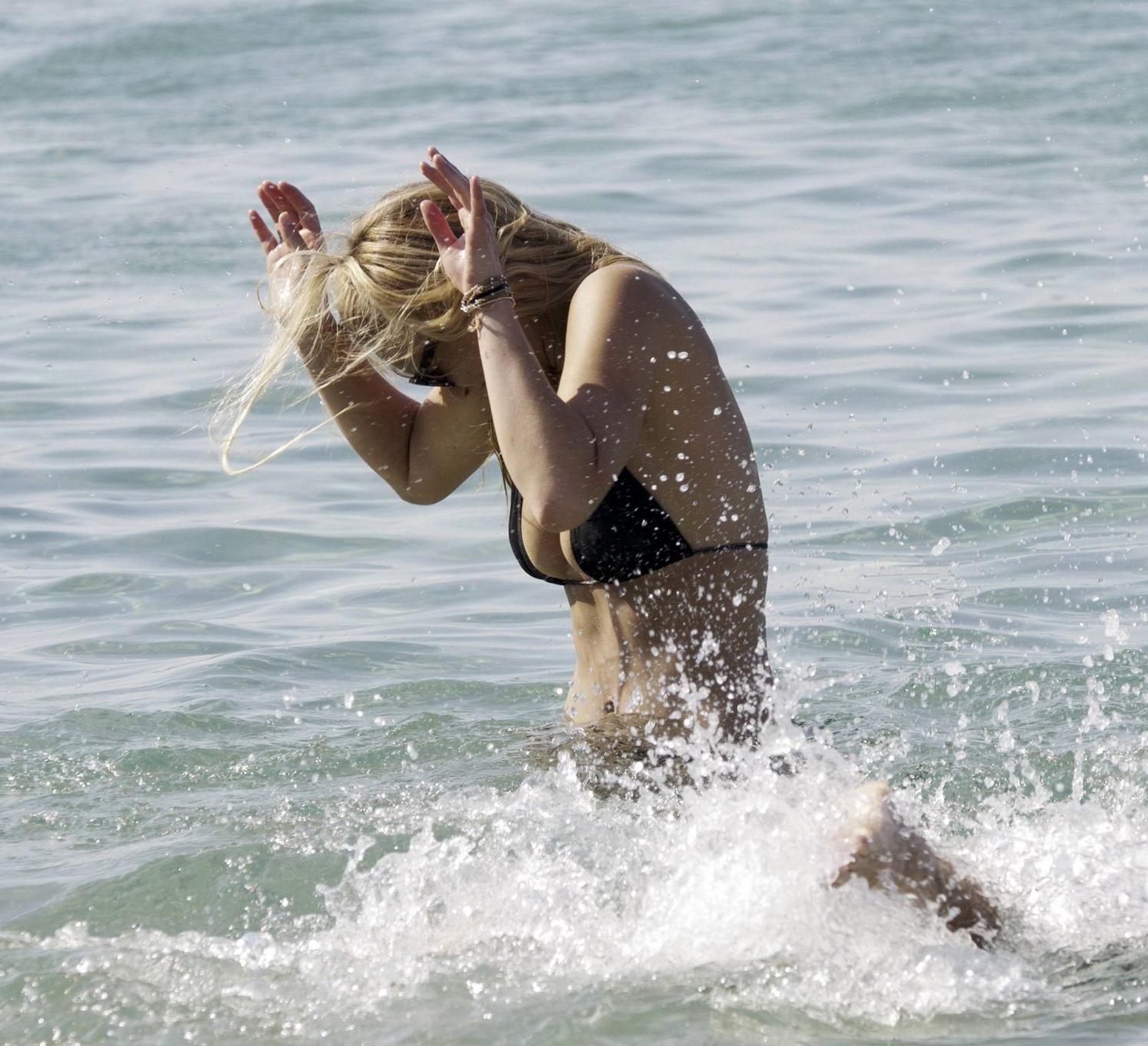 16P Bar Refaeli busty wearing black bikini on a beach in Greece