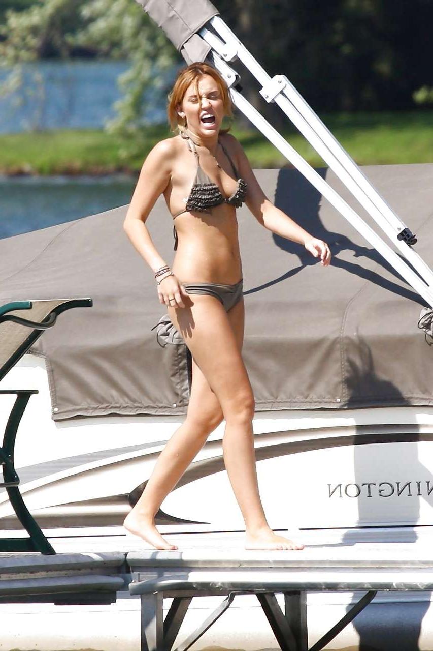 16P Miley Cyrus posing without bra and looking very sexy in bikini paparazzi picture