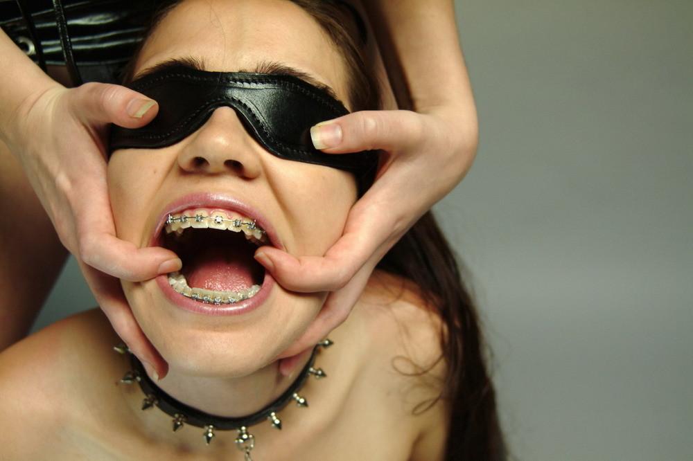 16P Dominatrix with a dildo plays with a pigtailed teen in braces