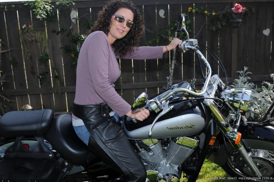 16P Fortyish biker babe strips next to her big chrome motorcycle