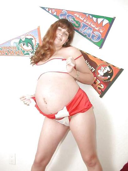 25P Pregnant brunette cheerleader undressing