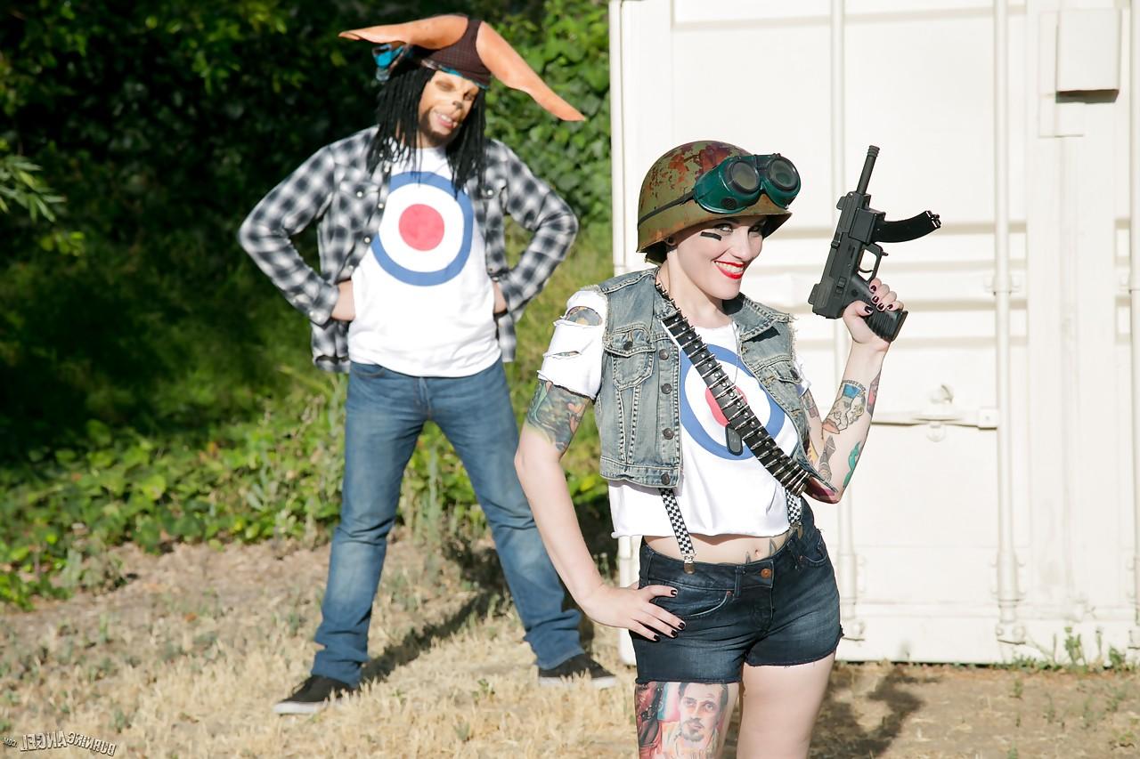 13P Tattooed chick with shaved head in army gear giving man in ape mask a BJ