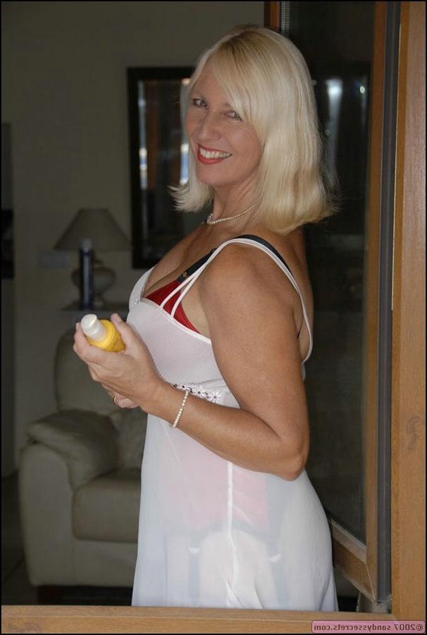 12P Sandy Spain takes off her stockings and shows her shaved pussy in the pool