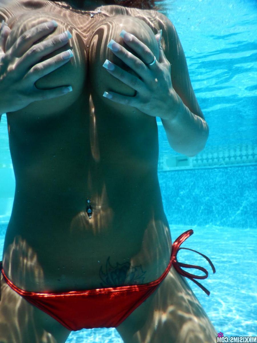 15P Busty hottie Nikki Sims falls out of her red bikini in the pool