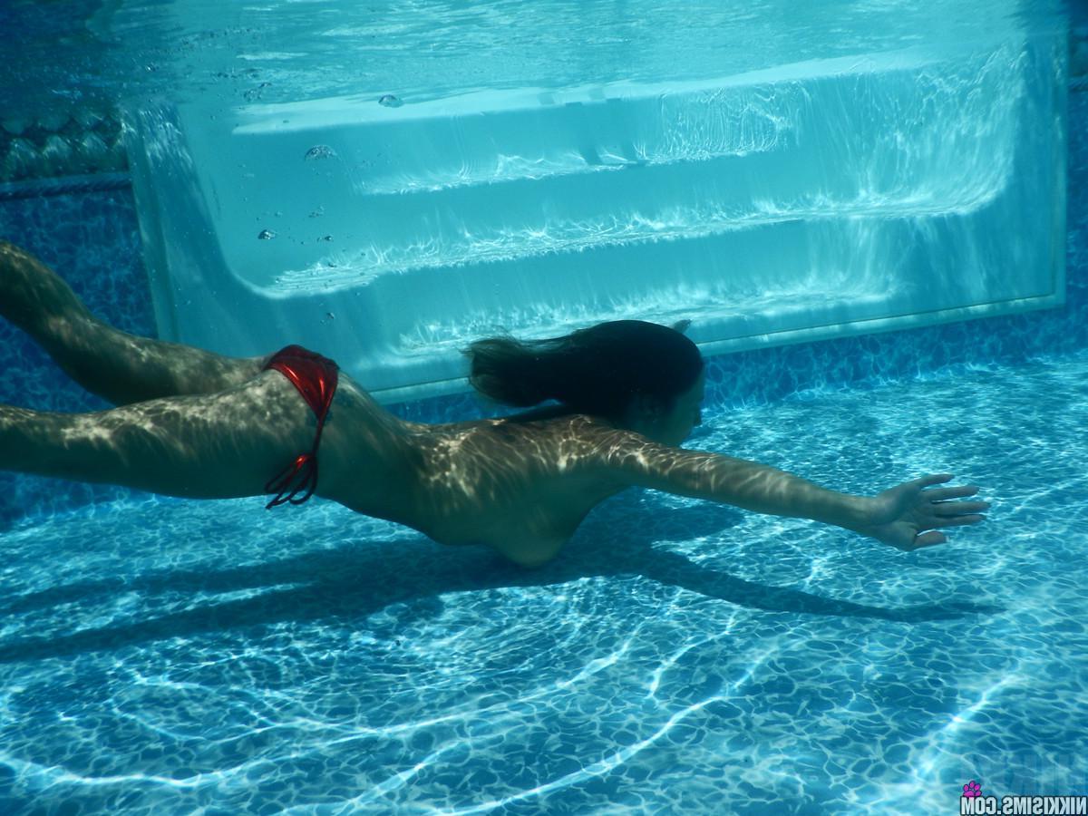 15P Busty hottie Nikki Sims falls out of her red bikini in the pool