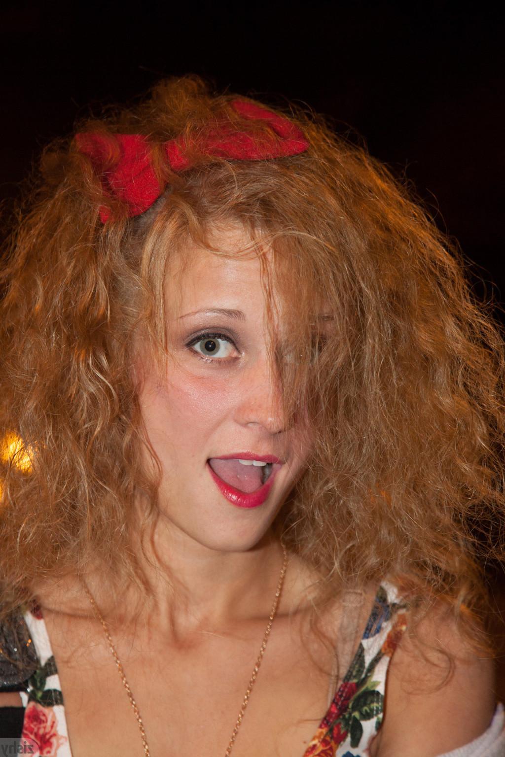 12P Rebel girl with curly hair smoking under a no smoking sign