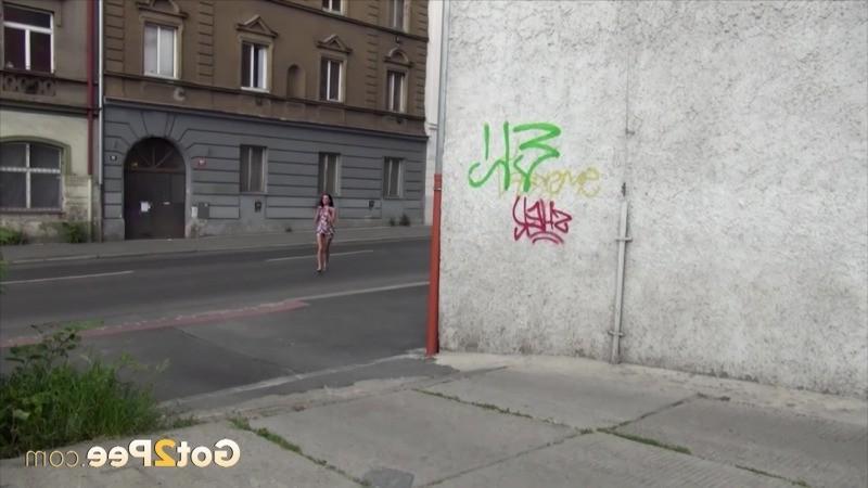 15P Dark haired girl pees next to a busy road outside
