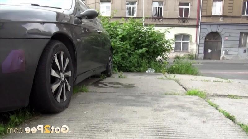 15P Dark haired girl pees next to a busy road outside