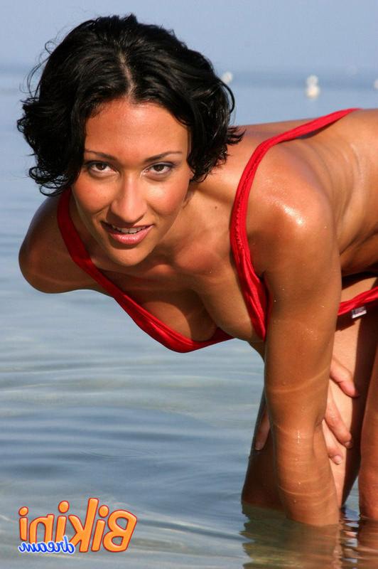 15P Babe wades in the ocean in her red sling bikini