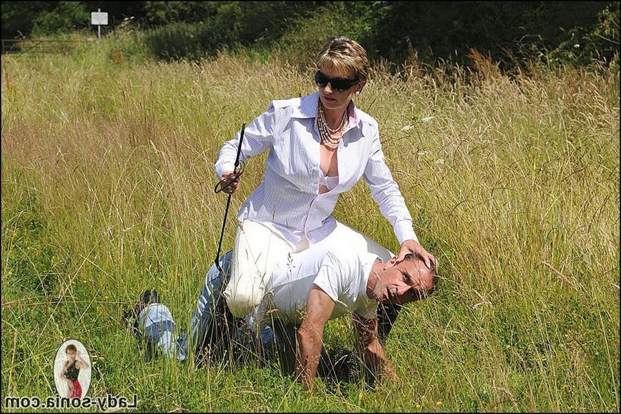 15P A mature femdom mistress in riding boots outdoors