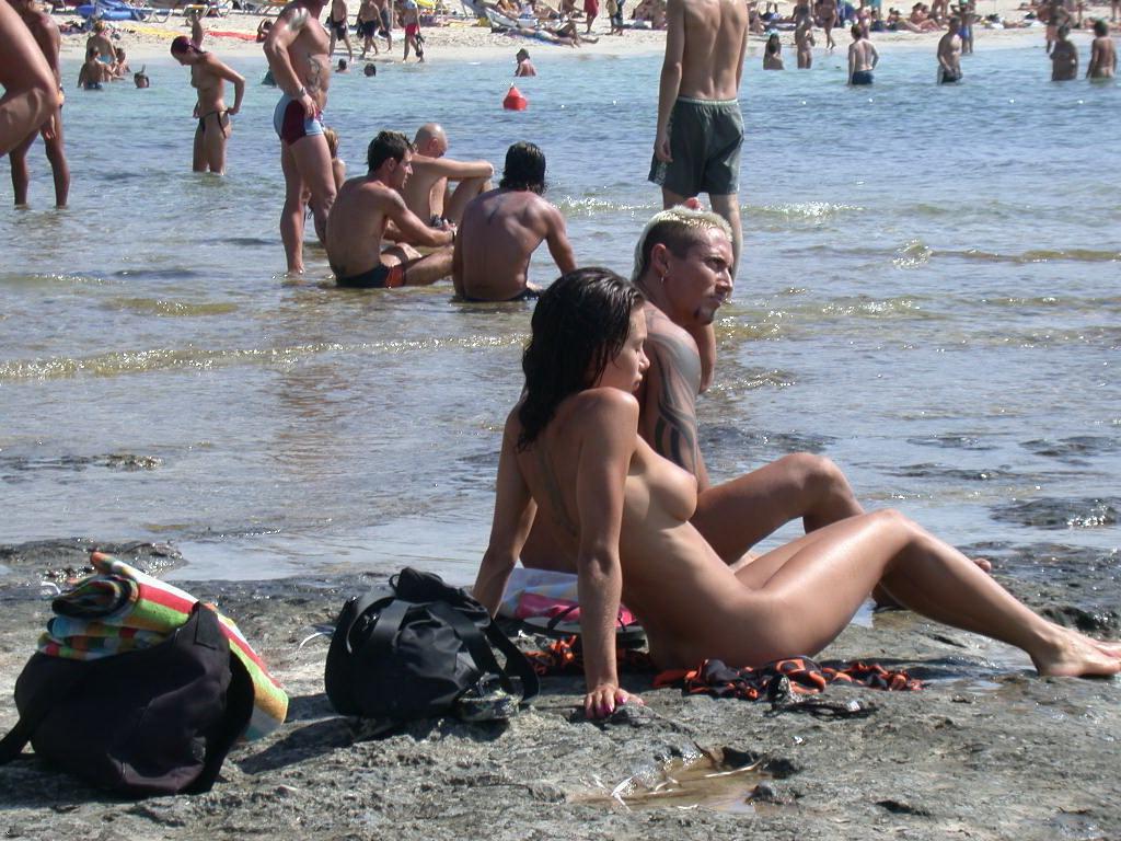 15P Long haired hottie lays around nude at the beach
