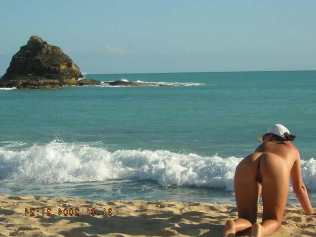 15P Long haired hottie lays around nude at the beach