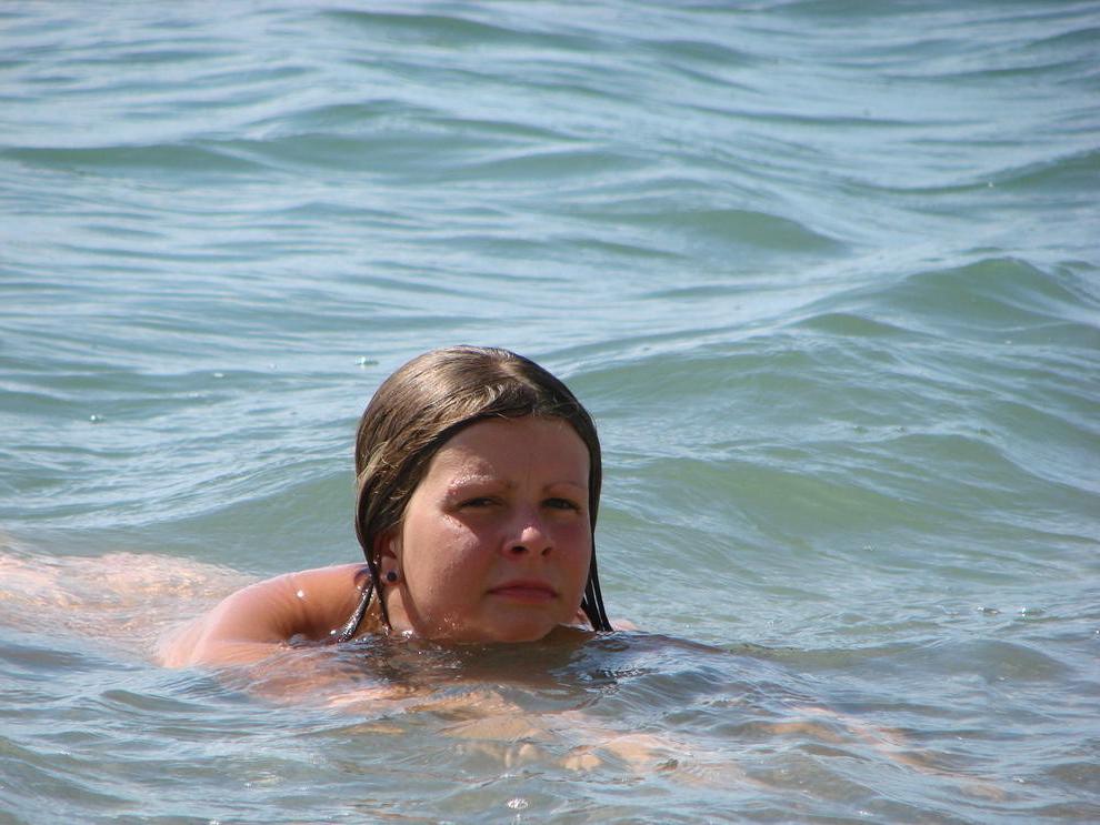 15P Long haired hottie lays around nude at the beach