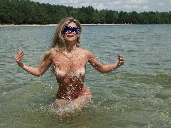 15P Long haired hottie lays around nude at the beach