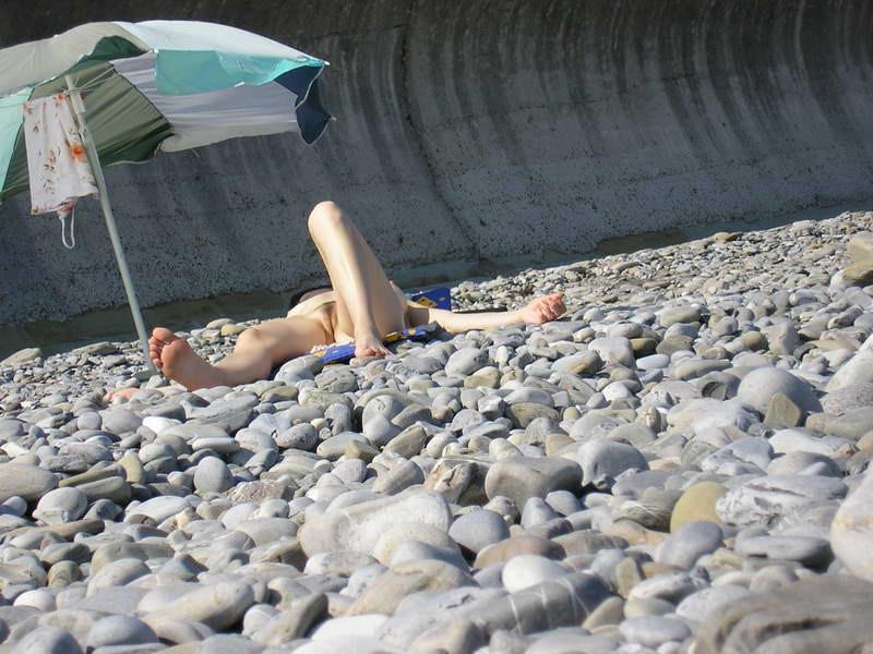 15P Long haired hottie lays around nude at the beach