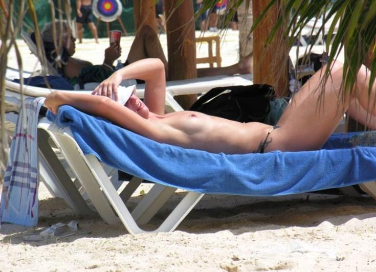 15P Long haired hottie lays around nude at the beach