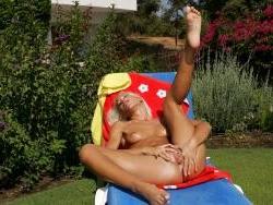15P Sun bathing beauty plays with her pink vibrator