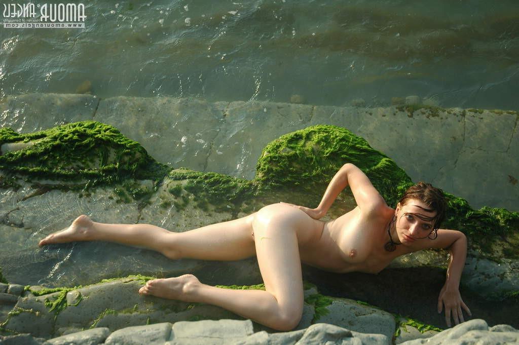 18P Thin sexy babe posing nude on rocks by water