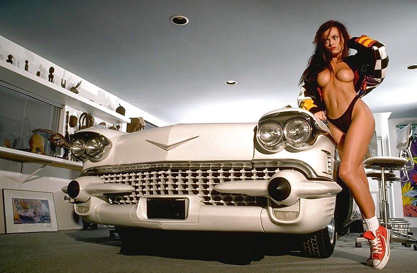 19P Naked brunette posing by car and artwork