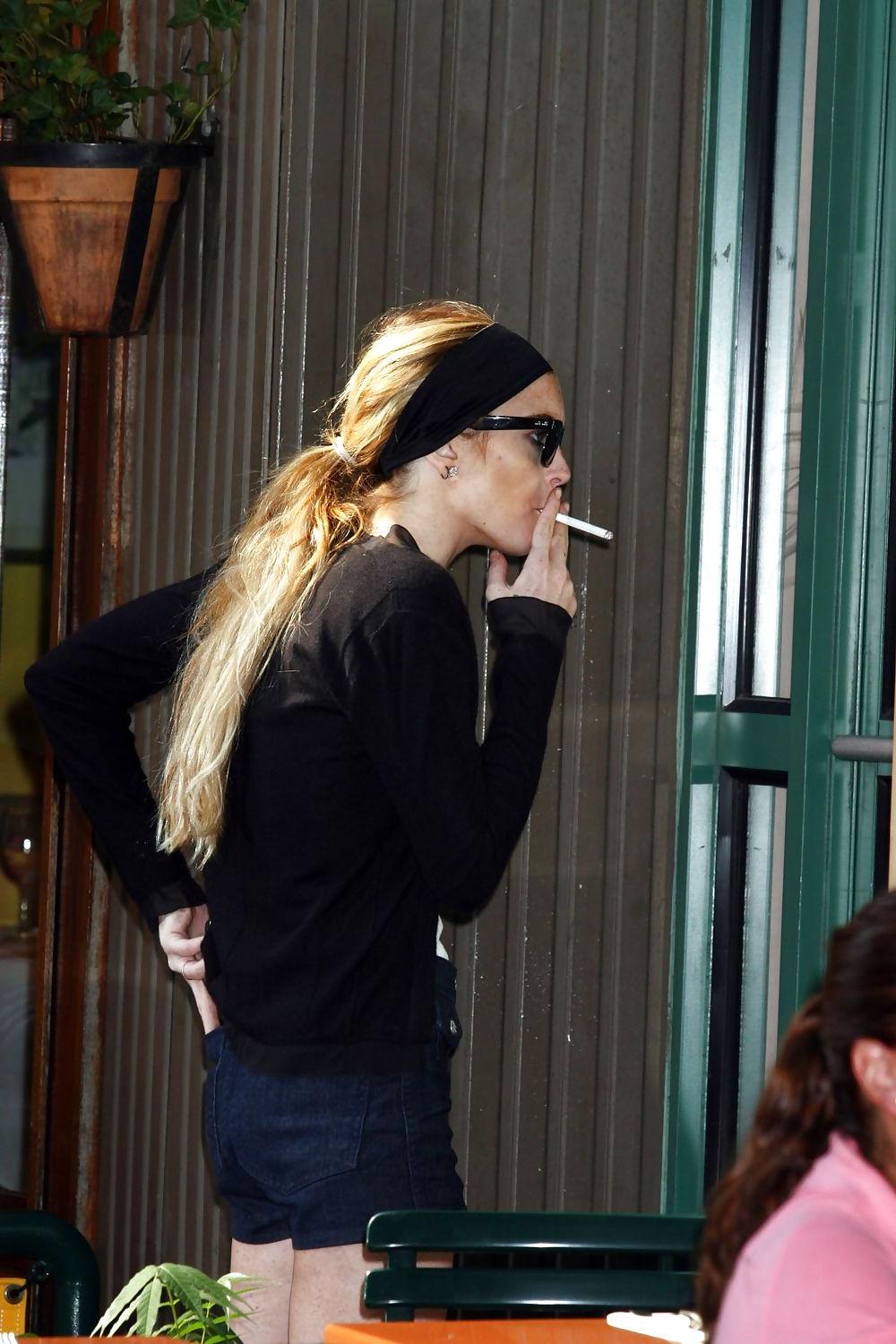 25P Lindsay Lohan is leggy smoking a cigarette in denim shorts