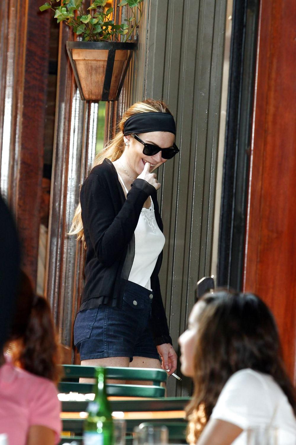 25P Lindsay Lohan is leggy smoking a cigarette in denim shorts
