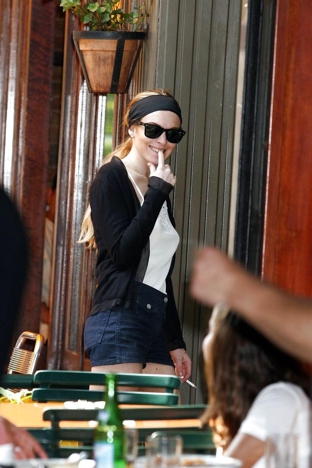 25P Lindsay Lohan is leggy smoking a cigarette in denim shorts