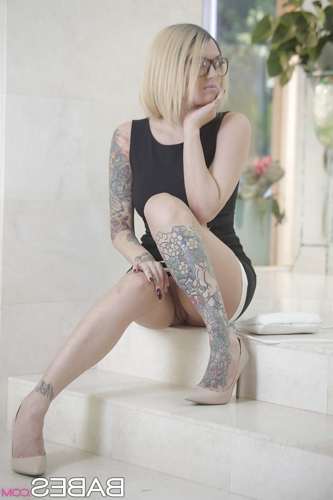 16P Inked babe in glasses revealing shaved pussy after shedding dress