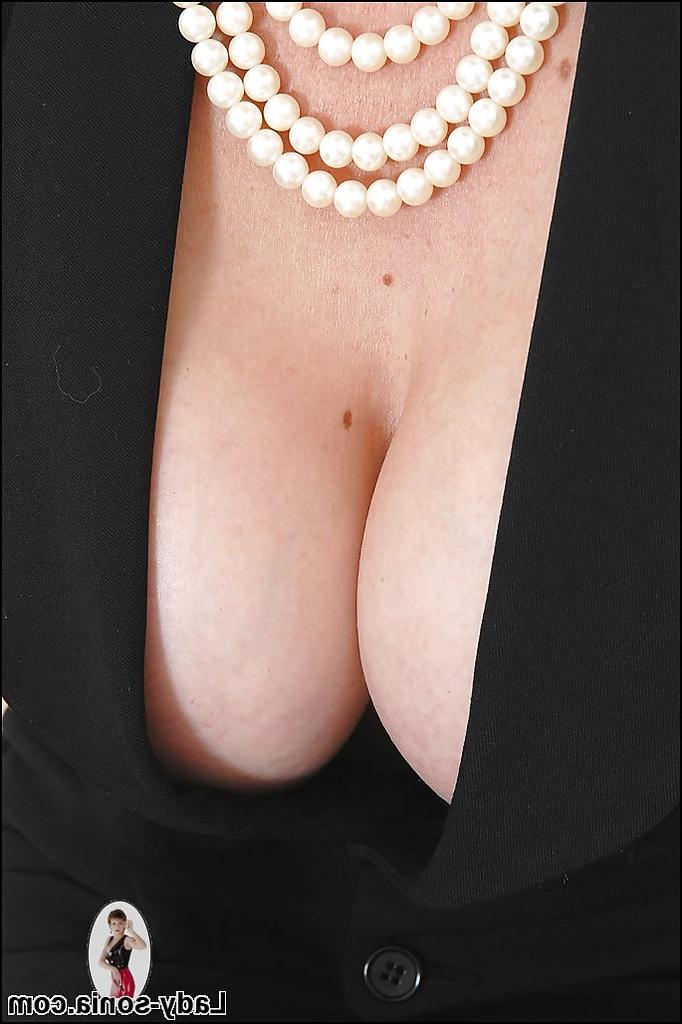 14P Shapely mature lady in glasses posing in a low neckline dress
