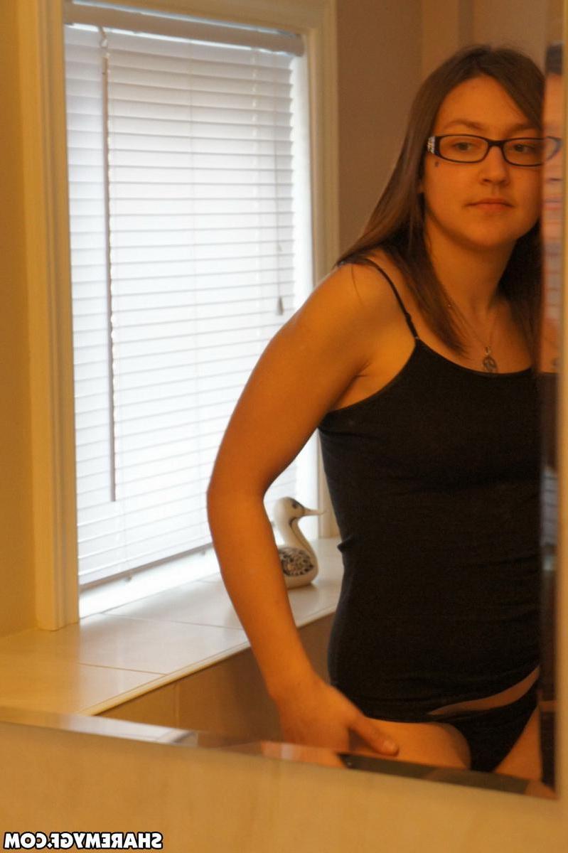 19P Hot brunette teen in glasses poses for the camera