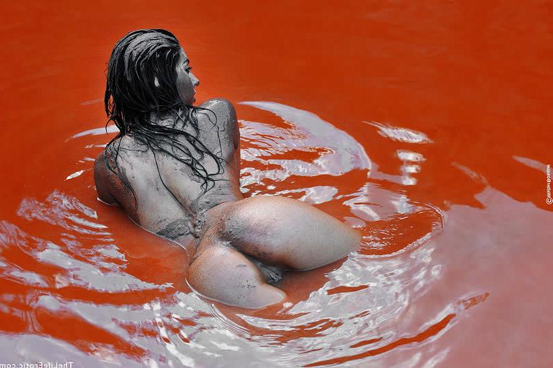 16P Nude beauty smearing her body in red mud outdoors in rocky pool